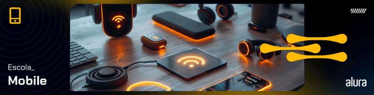 Mesa com dispositivos móveis e acessórios conectados destacando a Escola Mobile da Alura.